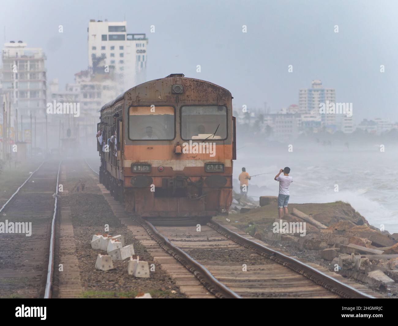 Train arriving through the fog to Kollupitiya Railway Station in Colombo, Sri Lanka. The station is one of the busiest railway stations on the Coastal Stock Photo