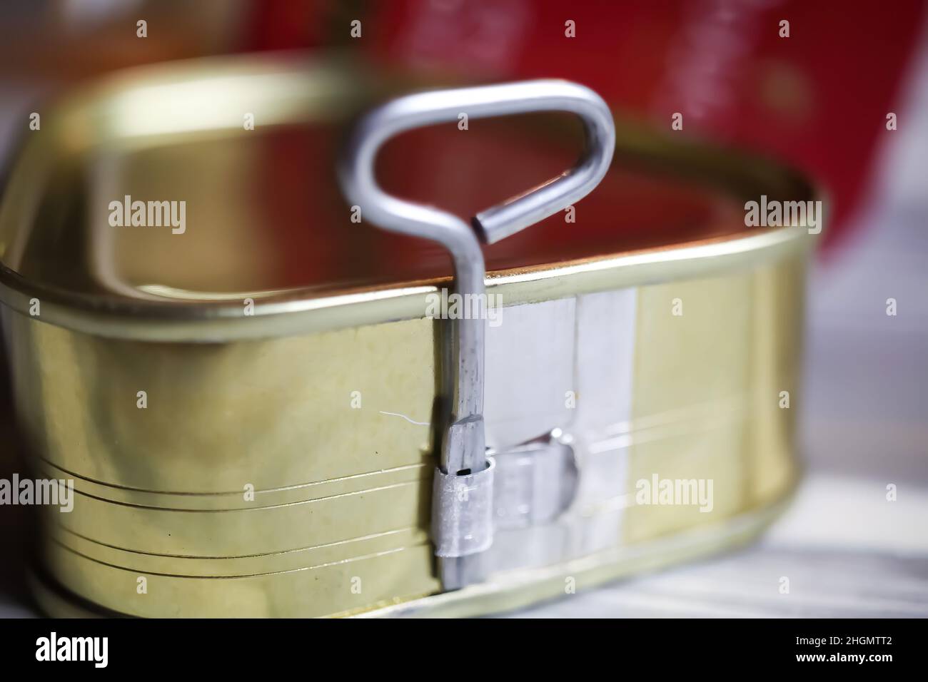 Makro closeup of isolated twist key can opener of metal trinagular food tin on white wood table Stock Photo
