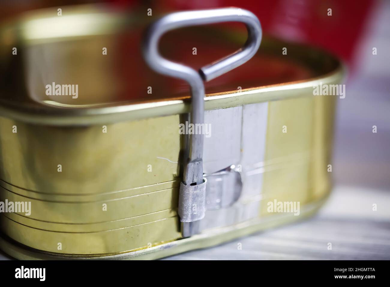 Makro closeup of isolated twist key can opener of metal trinagular food tin on white wood table Stock Photo