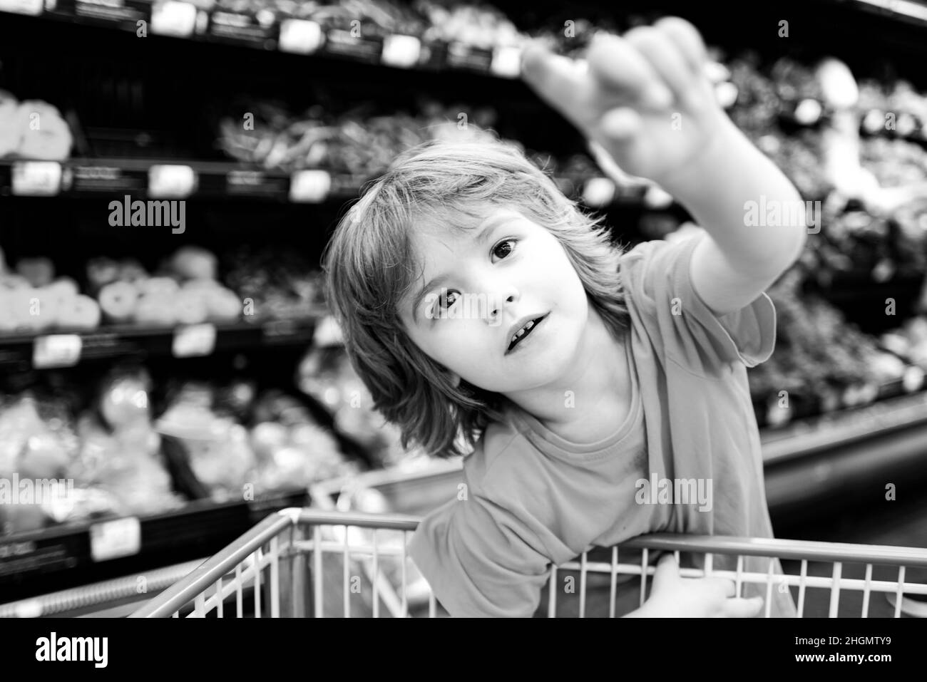 Sale, consumerism and people concept - kids with food in shopping cart at grocery store. Stock Photo