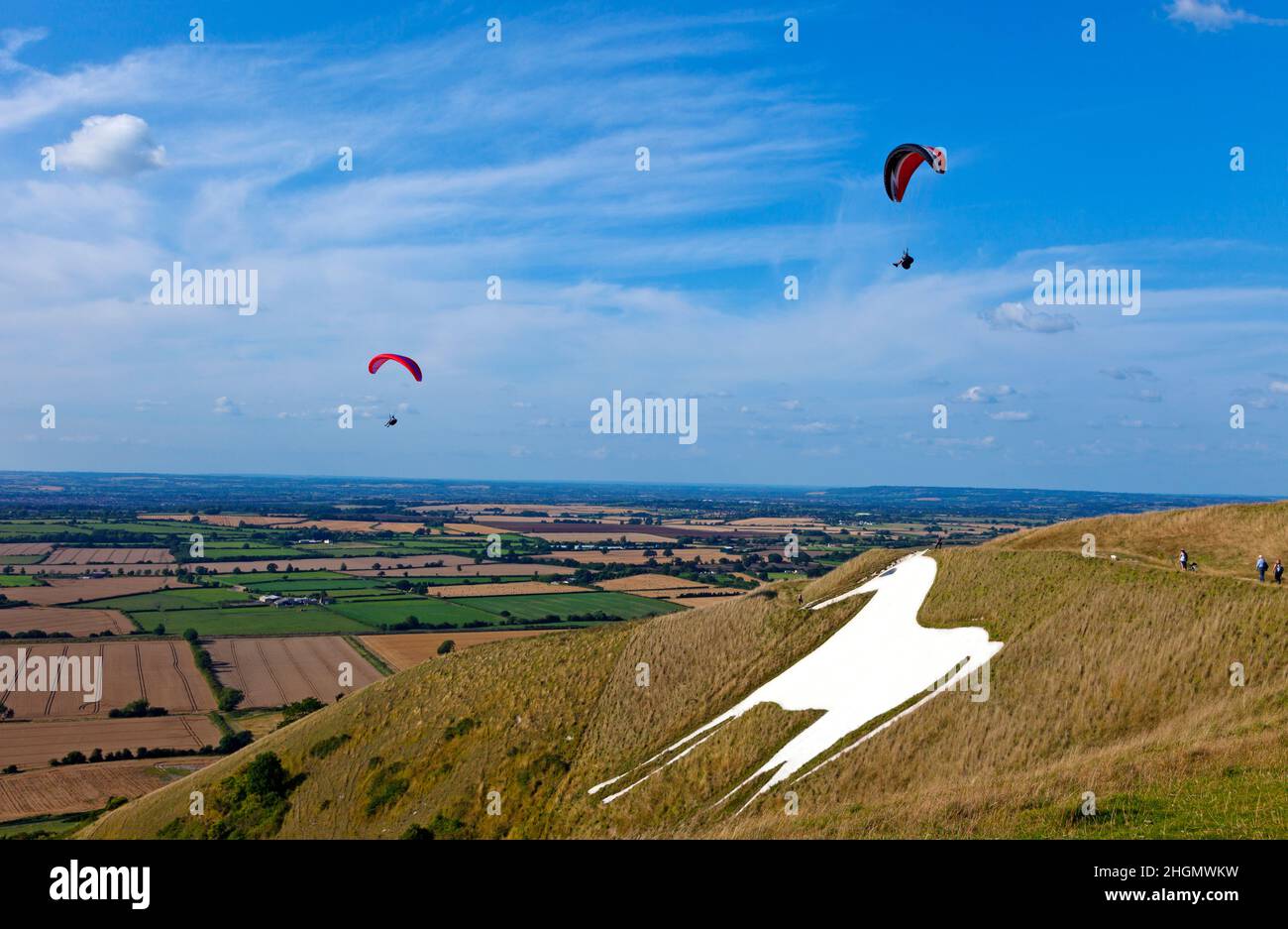 Hang gliders at Westbury White Horse chalk figure Wiltshire summer's day blue sky some white clouds copy space white horse in image Stock Photo