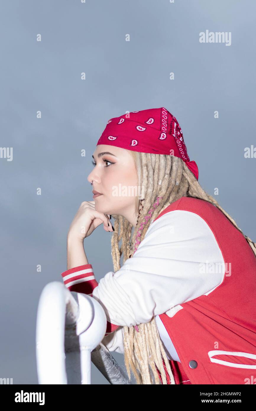blonde woman with dreadlocks and a red headscarf pensive Stock Photo