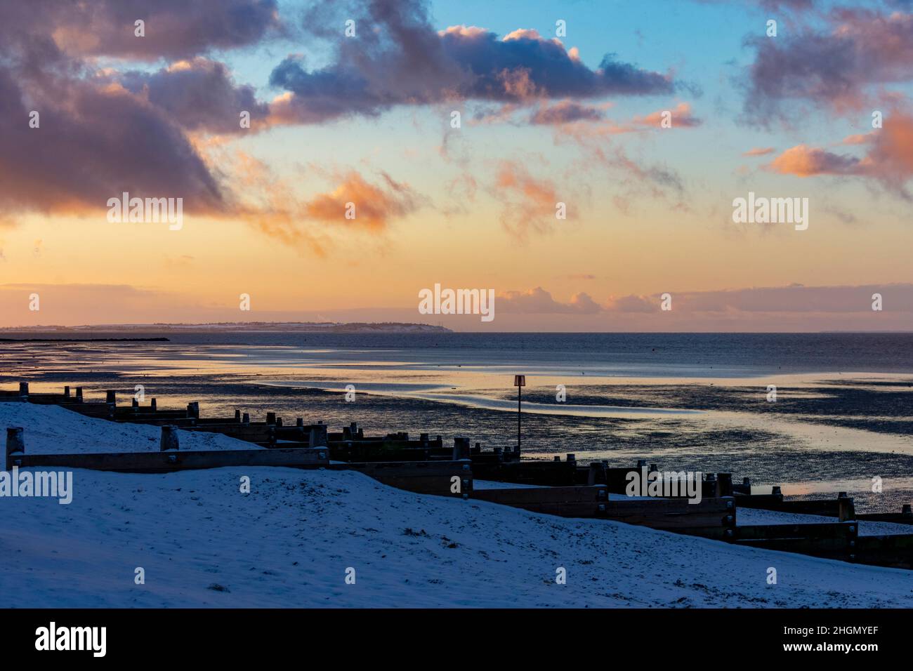 Herne Bay - a look west during the back-edge of a heavy snow shower that occurred before sunset. The beach and Sheppey can be seen coated in snow. Stock Photo
