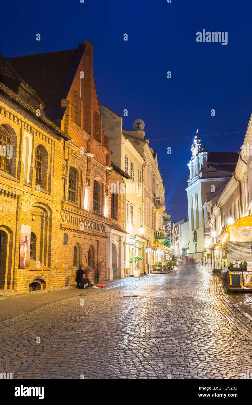 Vilnius Lithuania. Illuminated Facades Of Ancient Buildings On Famous Pilies Street, Old Town, Night Stock Photo