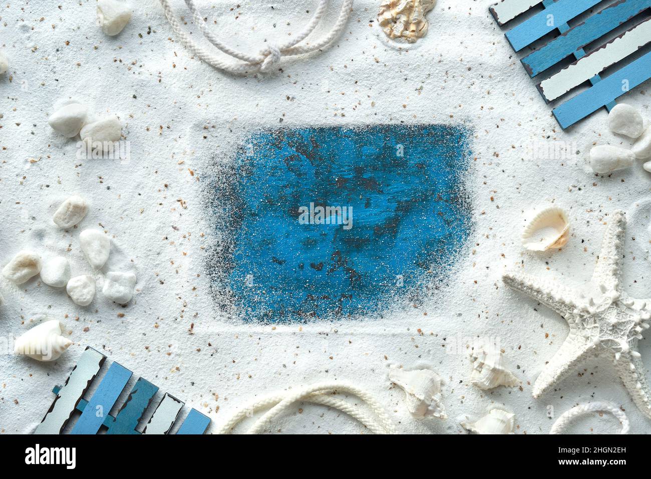 Sand frame, seashells, starfish, cord.Monochromatic off white, turquoise blue flat lay, copy-space. Stock Photo