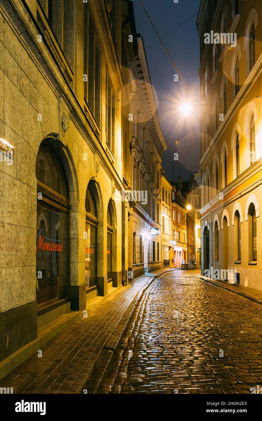 Riga, Latvia. Restaurant Cafe In Lighting In Night Illumination In Old Town In Maza Smilsu Street Stock Photo