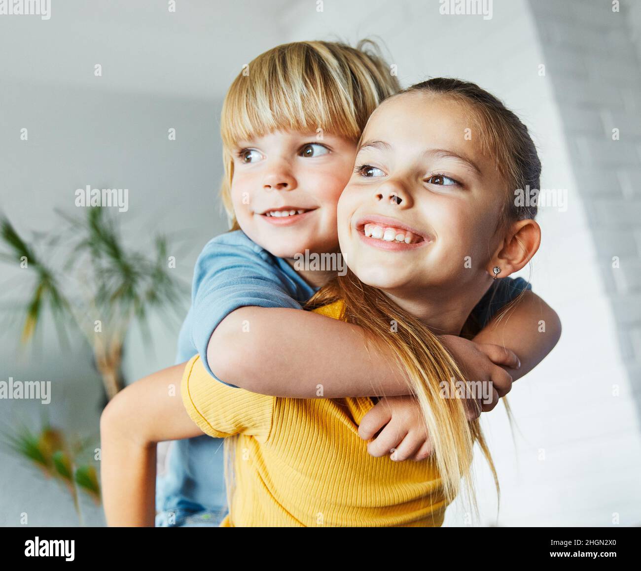 child girl boy childhood kid brother sister love family together fun happy joy happiness cute piggyback hugging embracing Stock Photo