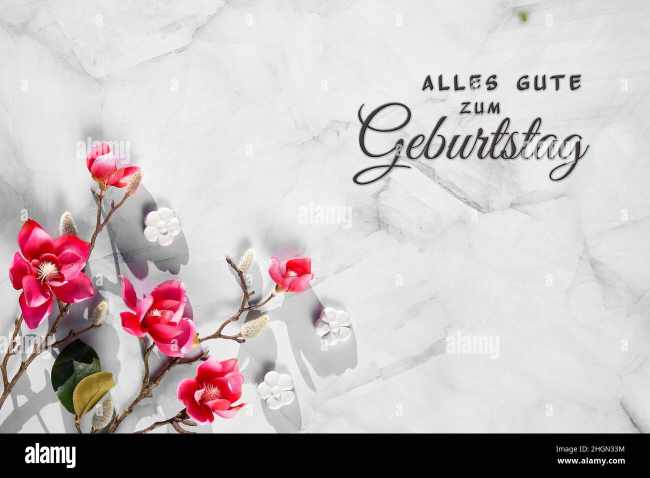 Pink magnolia twigs on stone.Text alles gute zum geburtstag means happy