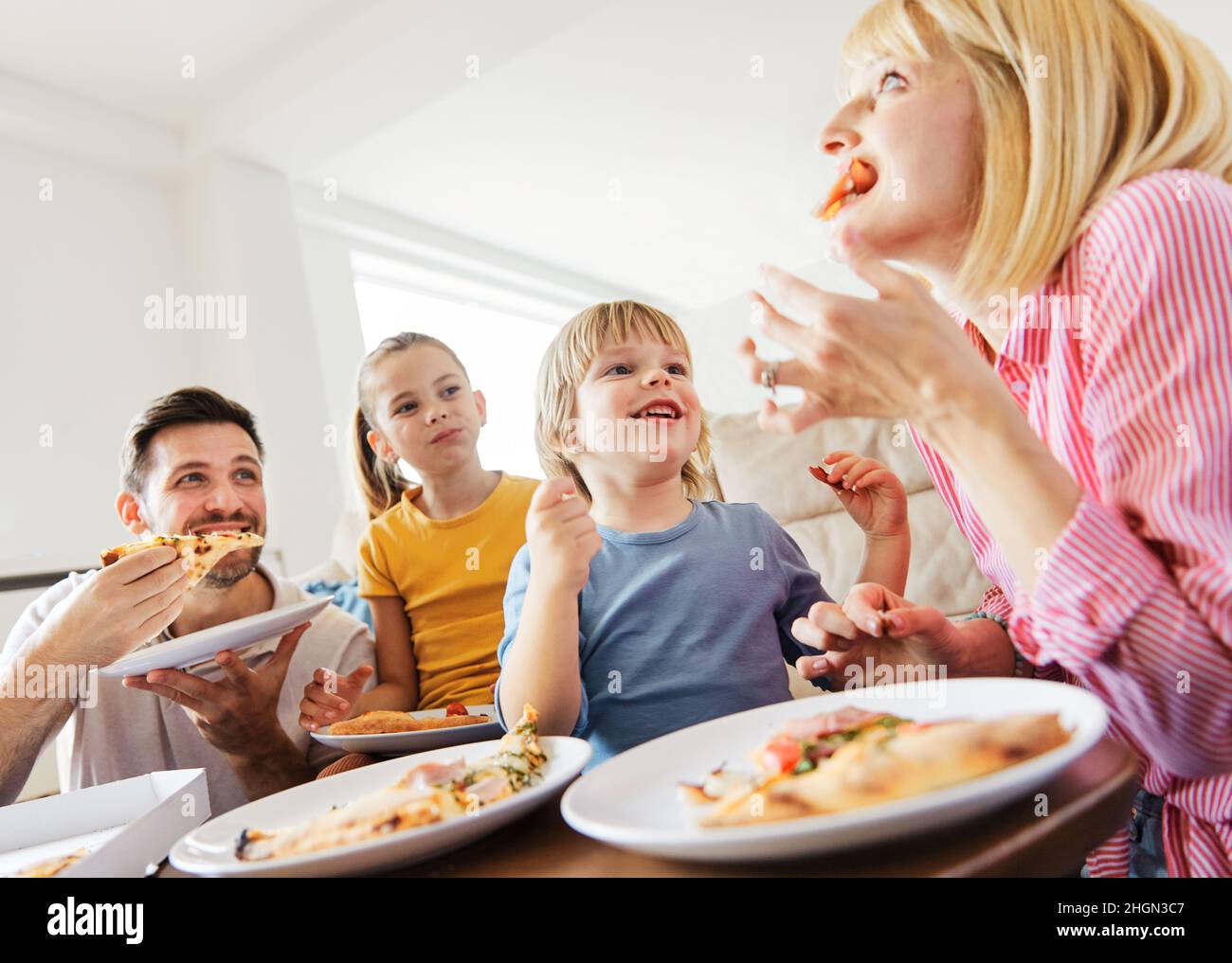 pizza family child food home eating son daughter mother father happy meal together lunch dinner man woman boy girl fun Stock Photo