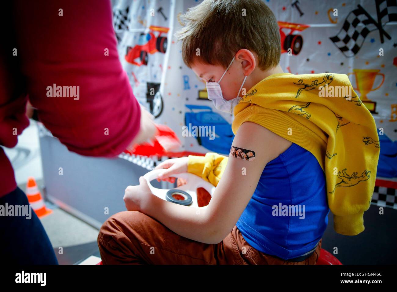 Iserlohn, Germany. 21st Jan, 2022. Iserlohn, Deutschland. 21st Jan, 2022. A boy has a patch stuck on after being vaccinated with the BioNTech/Pfizer children's vaccine in a COVID-19 vaccination and test center at the Olsen car dealership in Iserlohn, January 21, 2022. Credit: dpa/Alamy Live News Credit: dpa picture alliance/Alamy Live News Stock Photo