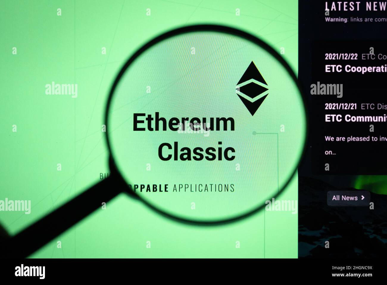 Ethereum Classic crypto company logo on a website, seen on a computer screen through a magnifying glass. Stock Photo