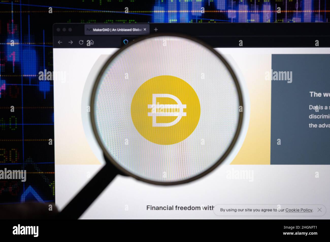 Dai crypto company logo on a website, seen on a computer screen through a magnifying glass. Stock Photo