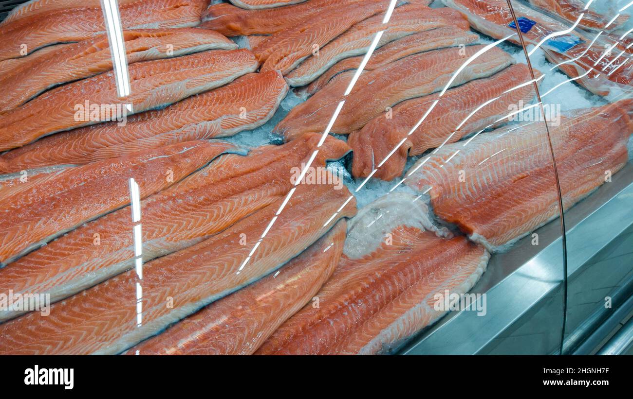 Fresh raw salmon fillet on ice on the counter in a fish store. red fish