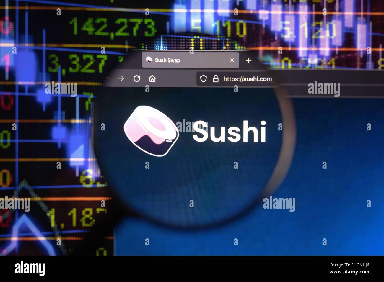 Sushi crypto company logo on a website, seen on a computer screen through a magnifying glass. Stock Photo
