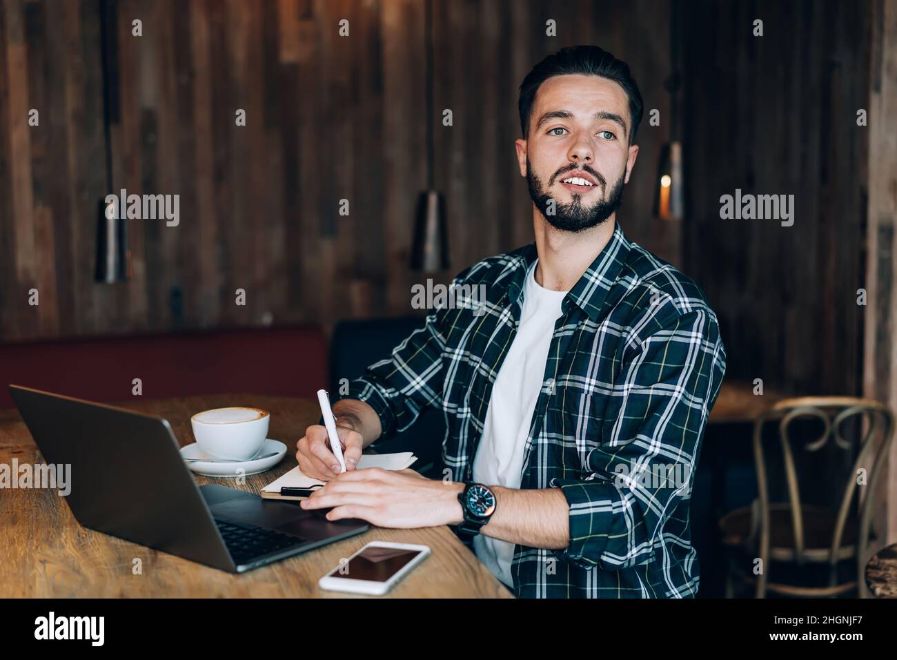 interested male freelancer sitting at table desktop with laptop computer for elearning Stock Photo