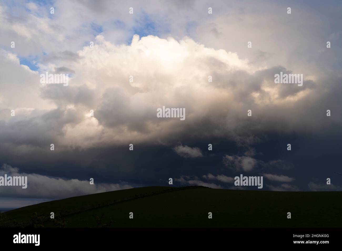 A rain cloud over farm land at St Abbs Head, Scotland Stock Photo