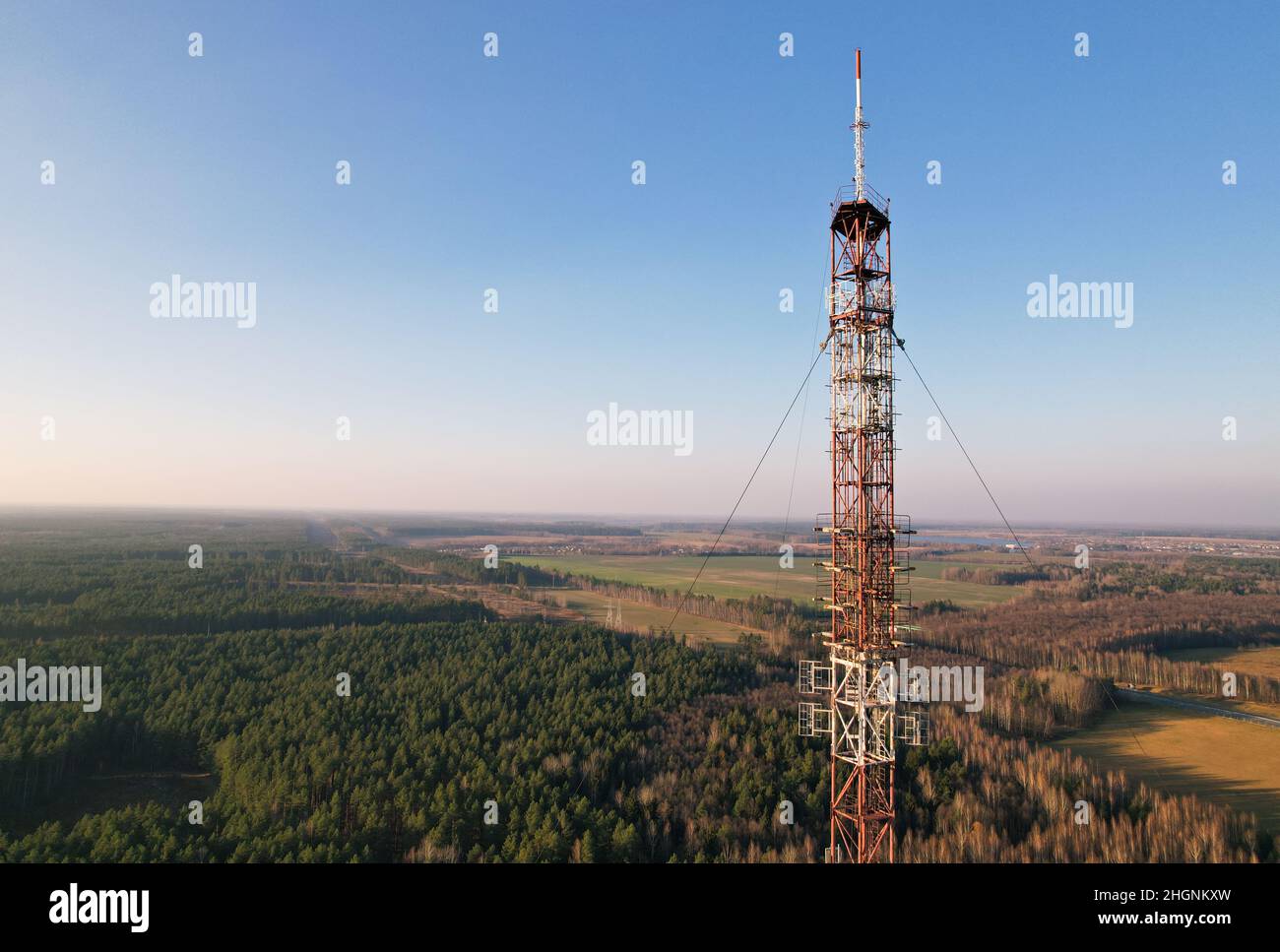 Telecommunications tower on the background of the blue sky in the countryside. Stock Photo
