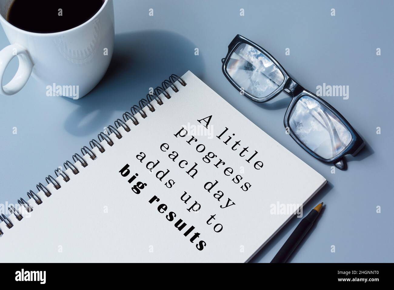 Motivational and inspirational quote on notepad with coffee, pen and glasses Stock Photo