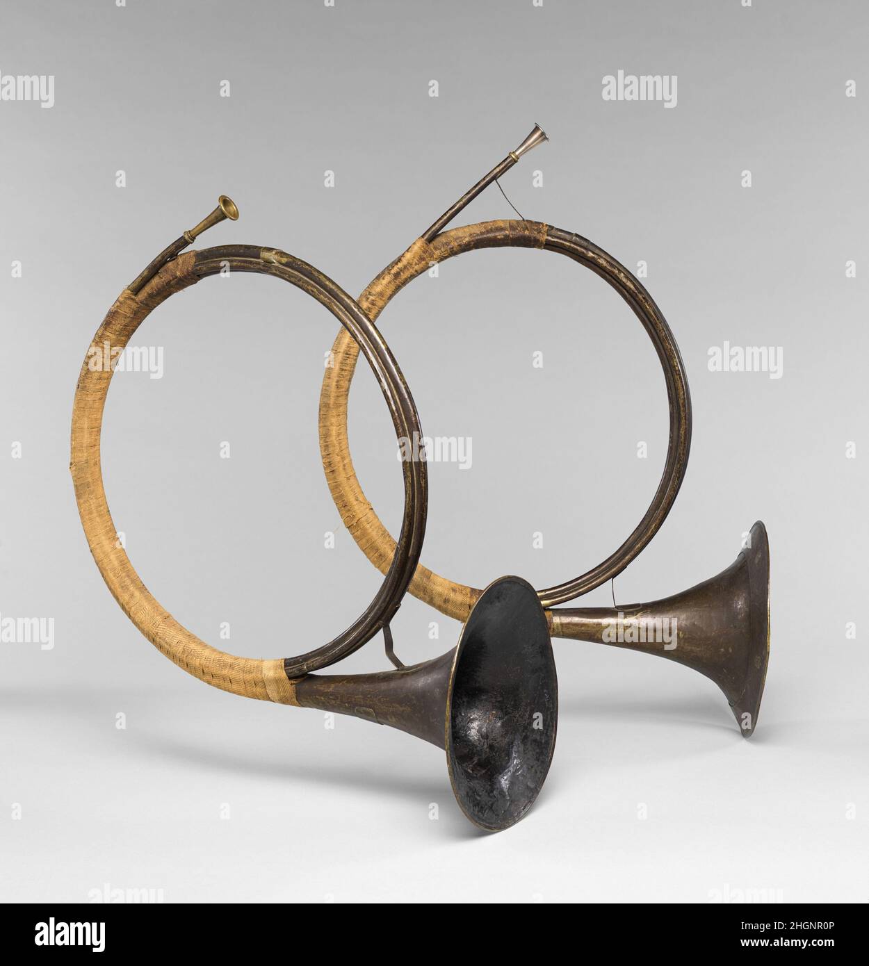 Pair of horns 1729 This pair of horns is of a transitional design that spans the instrument’s journey from the hunt to the orchestra. Although they could have been used in an outdoor context, they are representative of the more compact form of the horn that appeared with increasing frequency in orchestras in the first decades of the 18th century. It is likely that Handel’s horn players, most of whom hailed from Germany, would have played the Water Music on instruments similar to this. Made from brass and pitched in 16 foot ’D, this pair of horns is identical in all details of design and constr Stock Photo