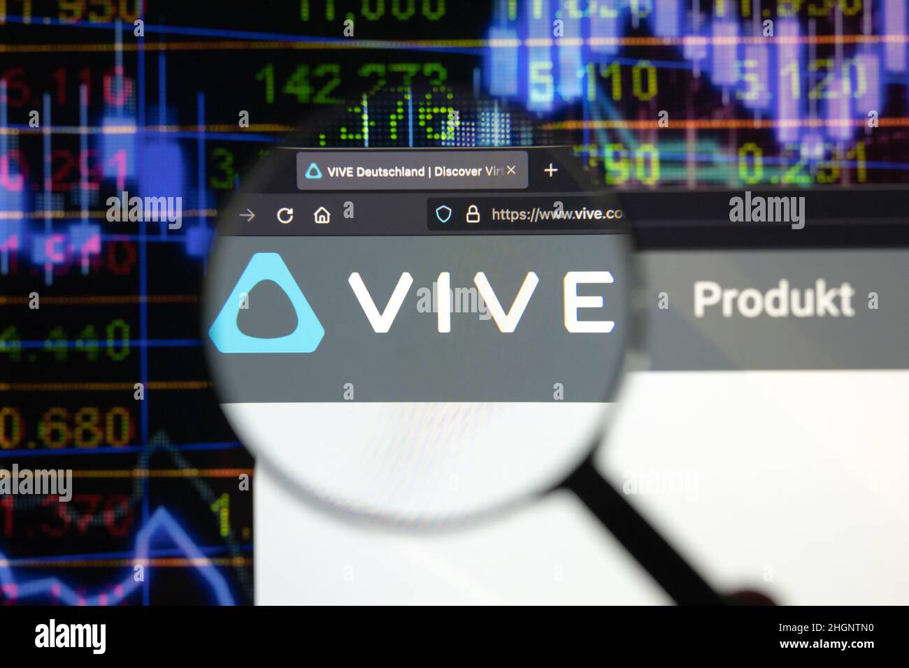 Vive company logo on a website with blurry stock market developments in the background, seen on a computer screen through a magnifying glass. Stock Photo