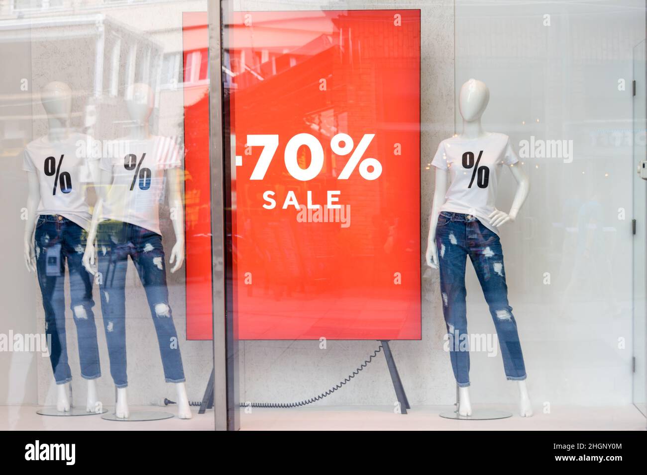 Shopping sale window display with mannequins wearing tshirts with sign