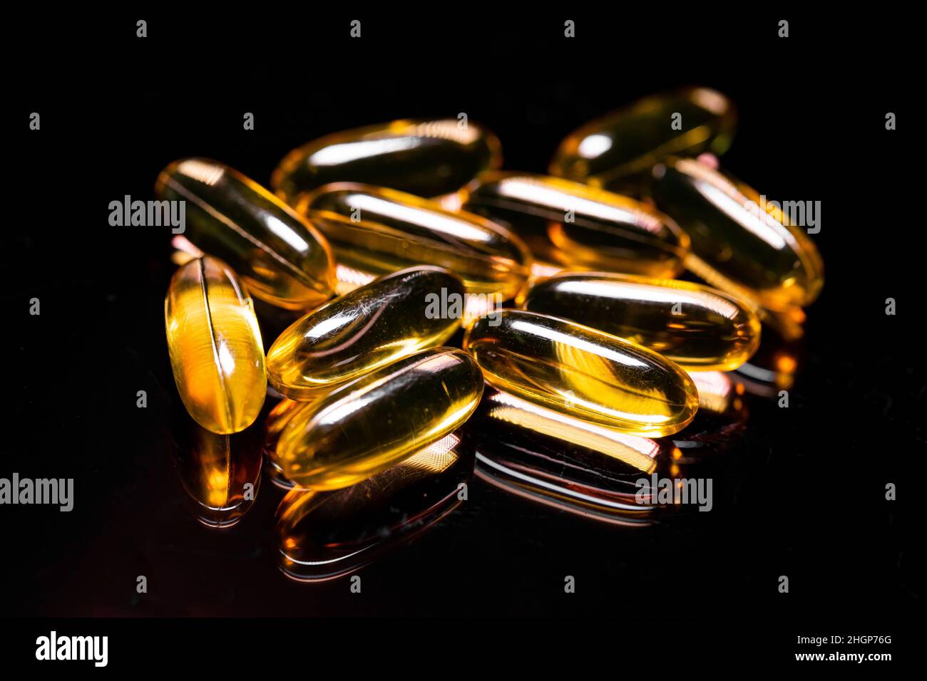 Macro Close up of Omega 3 gel capsule on a reflective black background