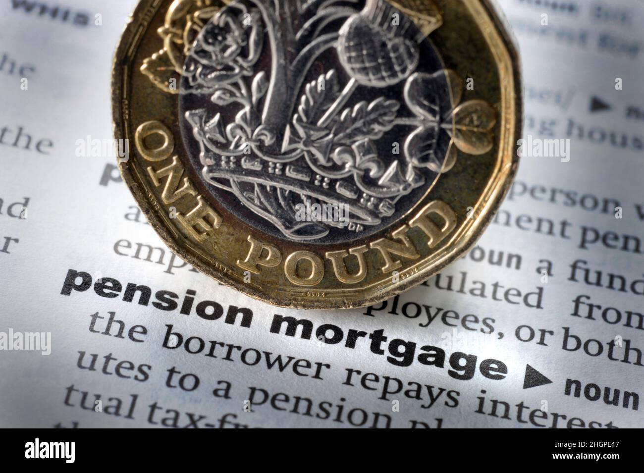 DICTIONARY DEFINITION OF WORDS PENSION MORTGAGE WITH ONE POUND COIN RE PENSIONS RETIREMENT COST OF LIVING RISING PRICES SAVINGS PENSIONERS ETC UK Stock Photo
