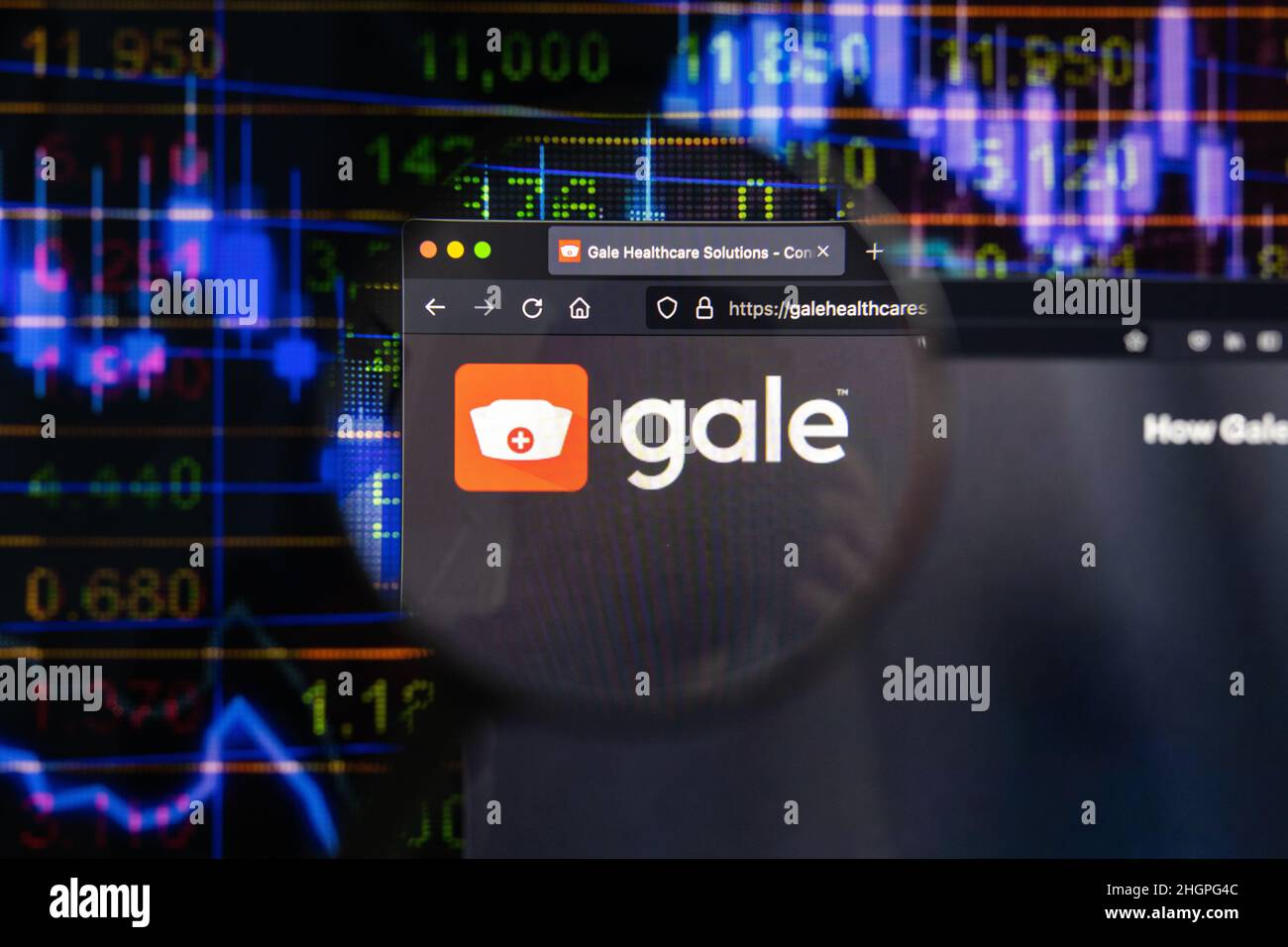 Gale company logo on a website with blurry stock market developments in the background, seen on a computer screen through a magnifying glass. Stock Photo