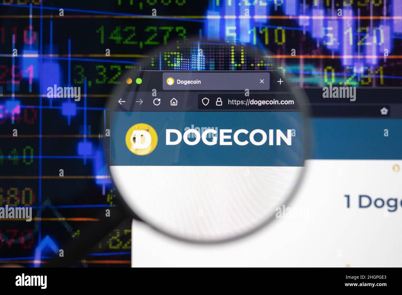 Dogecoin crypto company logo on a website, seen on a computer screen through a magnifying glass. Stock Photo