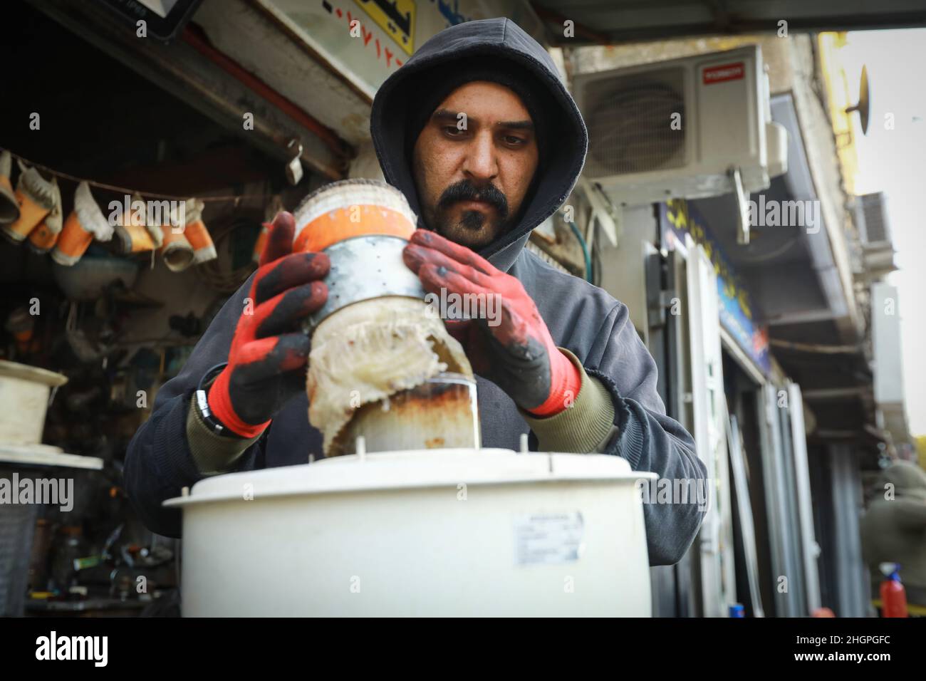 Baghdad, Iraq. 22nd Jan, 2022. An Iraqi worker fixes an oil heater at his as cold
