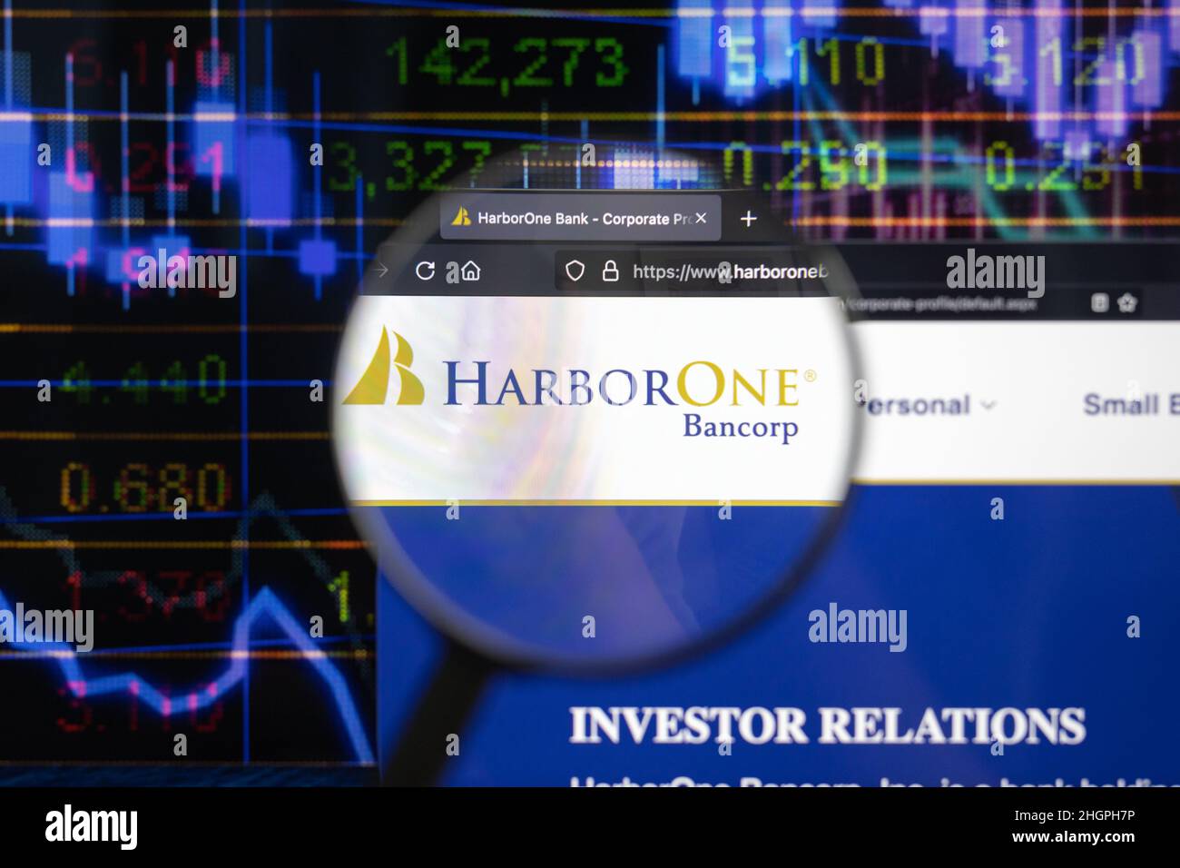 HarborOne company logo on a website with blurry stock market developments in the background, seen on a computer screen through a magnifying glass. Stock Photo