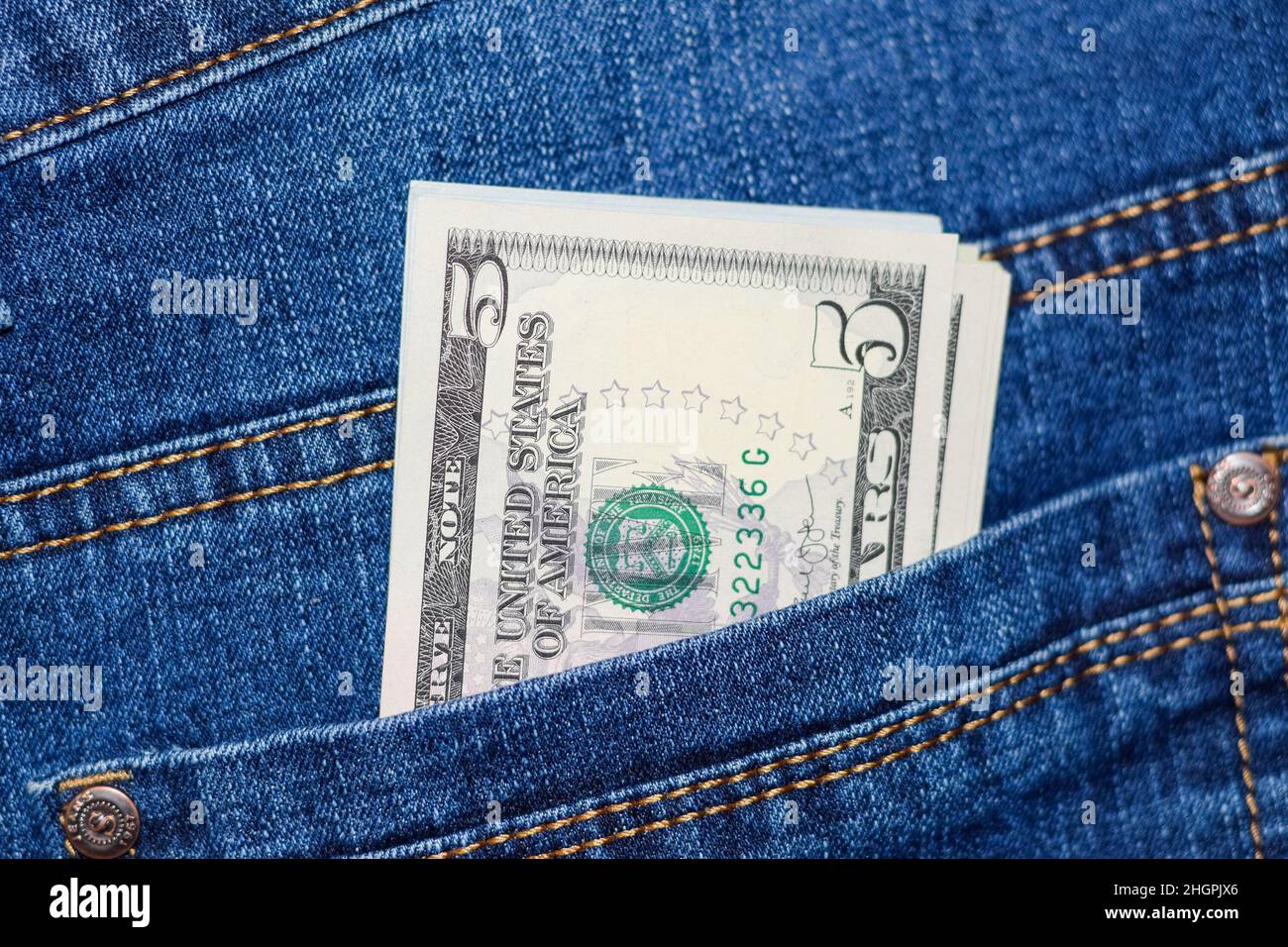 Dollars stick out of the pocket of jeans. Money in your pocket. Stock Photo