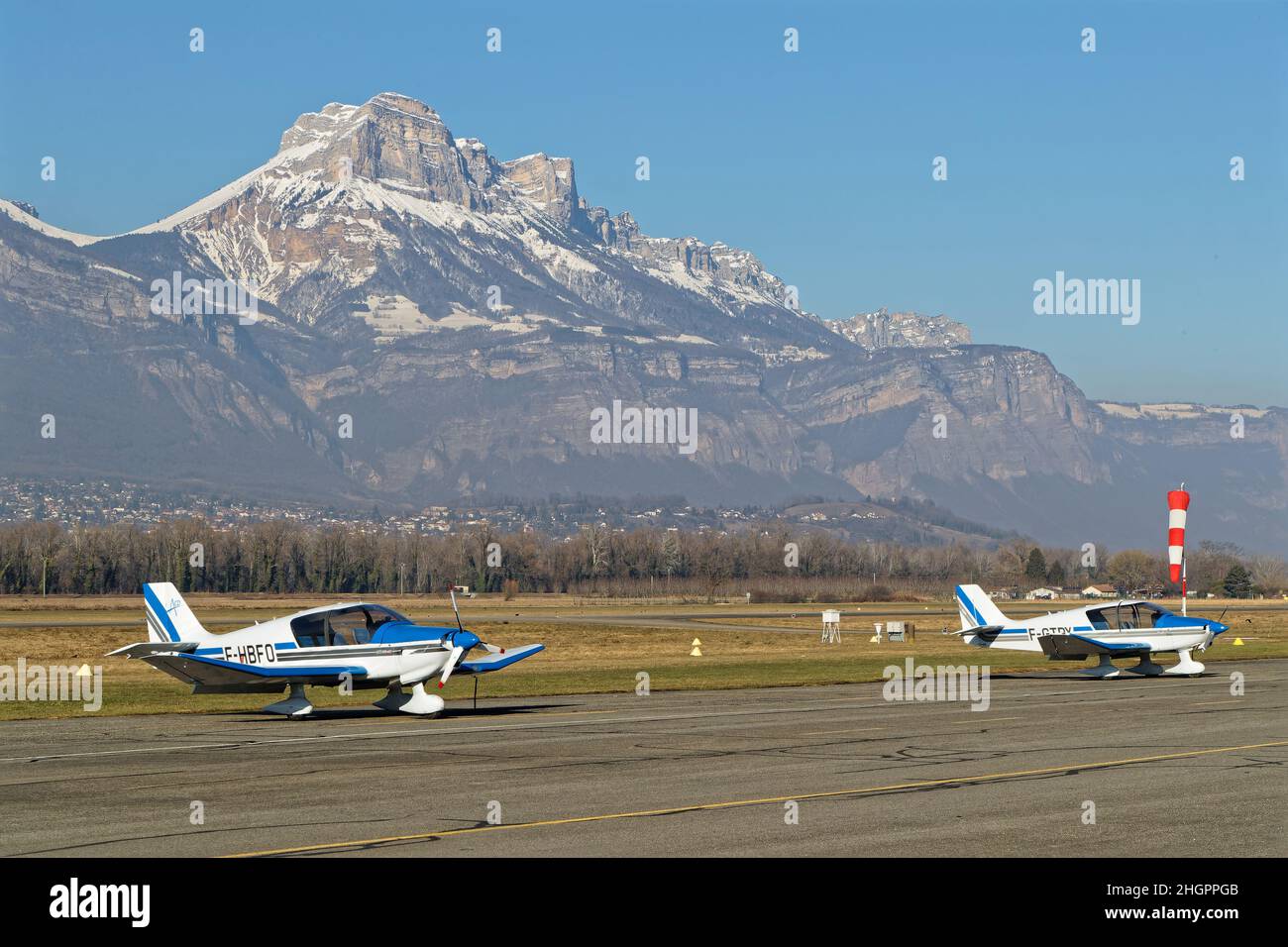 LE VERSOUD, FRANCE, january 14, 2022 : Small planes in Aerodrome de Grenoble-Le Versoud with Chartreuse mountain range in the background Stock Photo