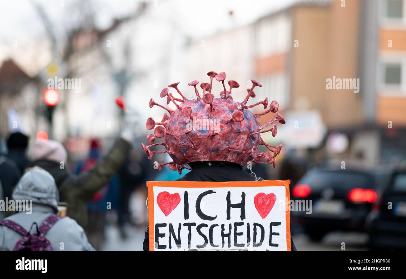 Hamburg, Germany. 22nd Jan, 2022. A participant of a demonstration against the Corona policy under the slogan 'Against exclusion, division and coercion' wears a headgear with a stylized virus on it. On his back he carries a sign with the inscription 'I decide'. Credit: Daniel Reinhardt/dpa/Alamy Live News Stock Photo