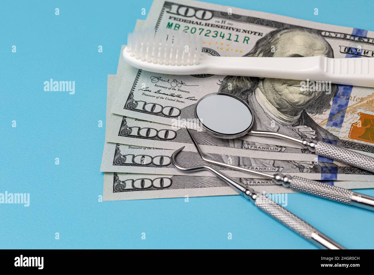 Dental cleaning tools with toothbrush and cash money. Oral health, exam and teeth cleaning concept. Stock Photo