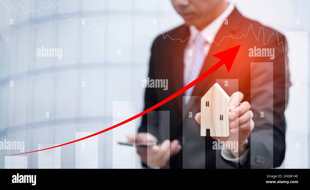 Concept of falling real estate market, down arrow and wooden house. The