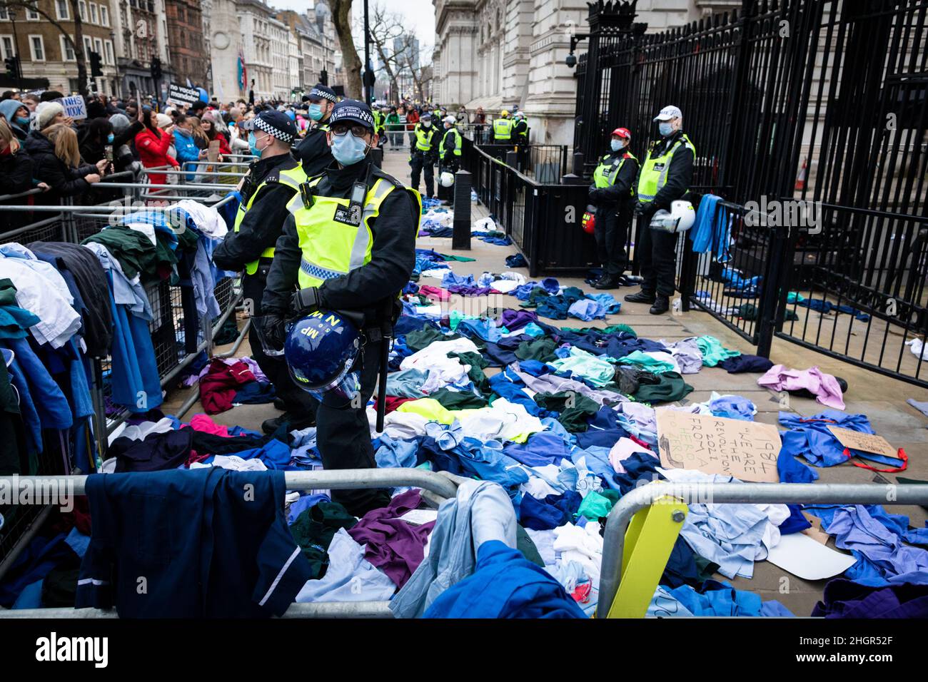 London, UK. 22nd Jan, 2022. Protesters throw NHS uniforms at Downing Street. As the mandate to get vaccinated against COVID-19 draws ever closer NHS workers join the protest. The anti-lockdown demonstration was organised by the World Wide Rally For Freedom movement. Credit: Andy Barton/Alamy Live News Stock Photo