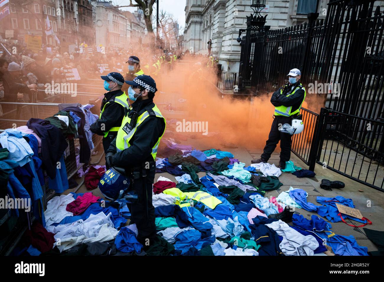 London, UK. 22nd Jan, 2022. Protesters throw NHS uniforms at Downing Street. As the mandate to get vaccinated against COVID-19 draws ever closer NHS workers join the protest. The anti-lockdown demonstration was organised by the World Wide Rally For Freedom movement. Credit: Andy Barton/Alamy Live News Stock Photo