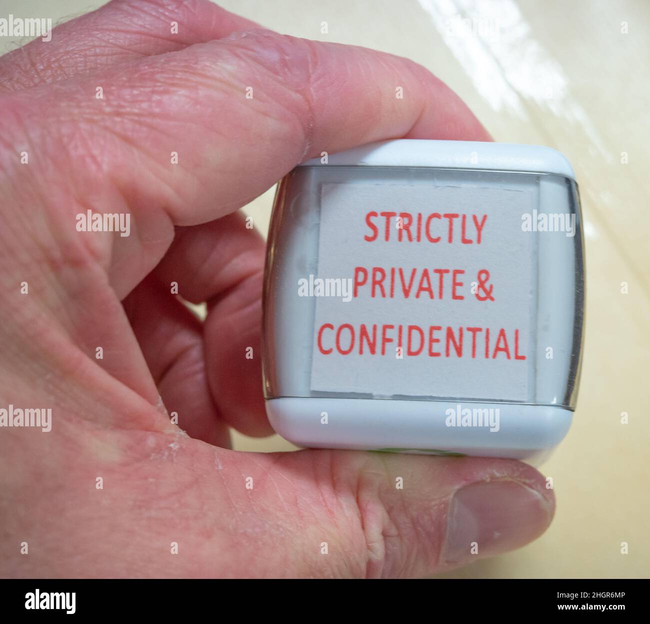 Unidentifiable male marking up a brown envelope with a Strictly Private