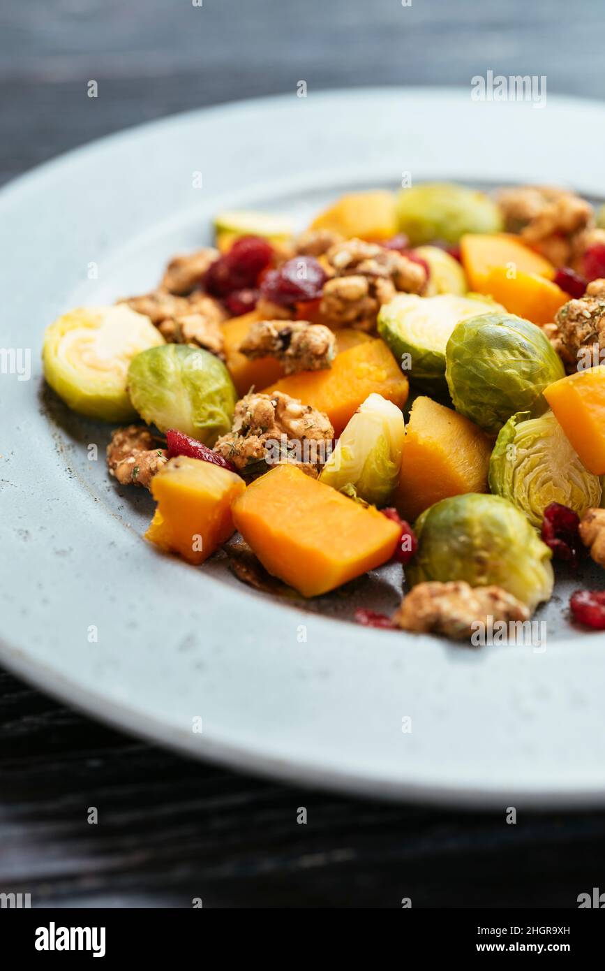Roasted Brussels Sprouts and Sweet Potatoes with dried cranberries and spicy walnuts. Stock Photo