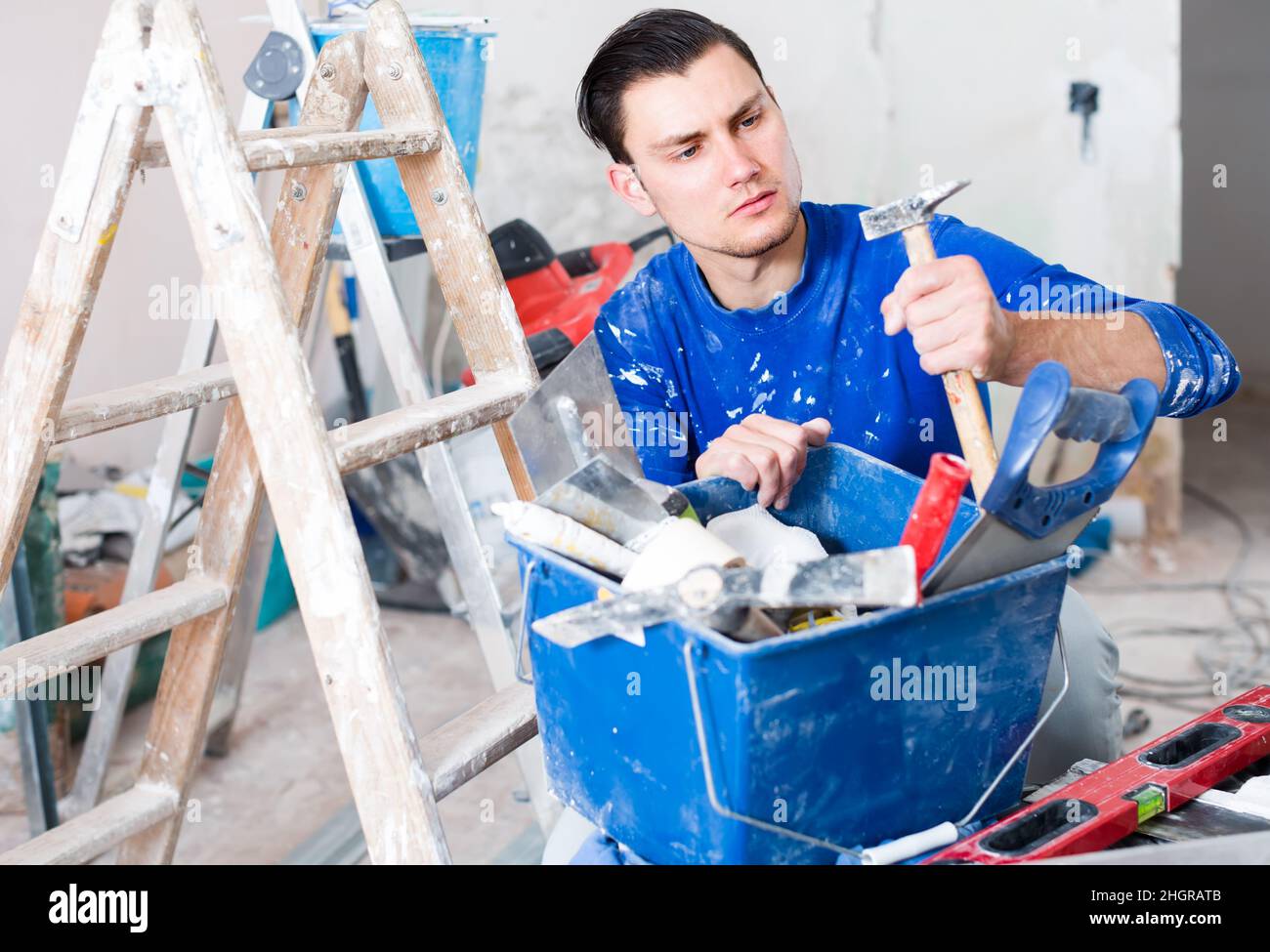 concentrated builder handyman choosing tool in toolbox Stock Photo