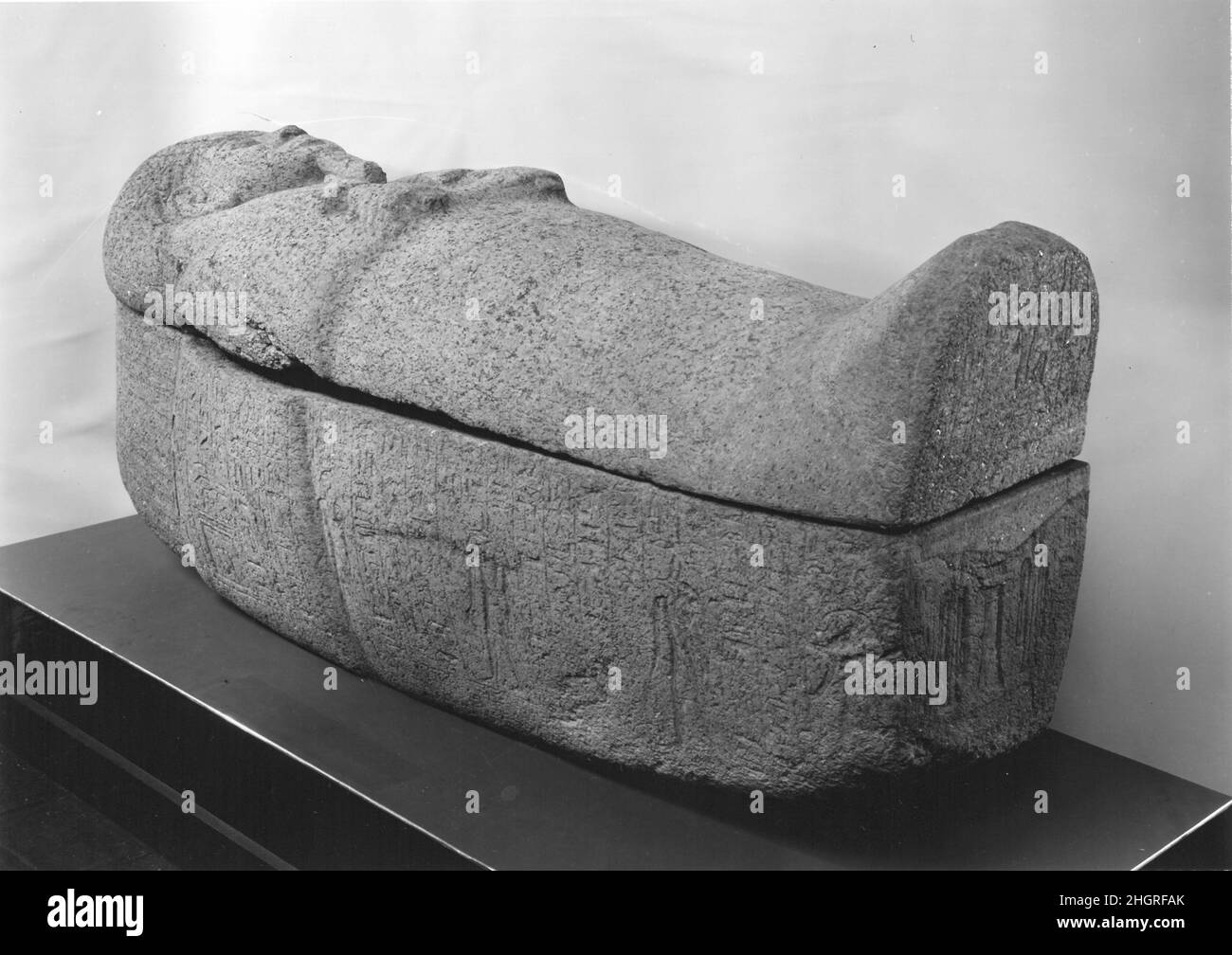 Sarcophagus of Usermontu ca. 1279–1213 B.C. New Kingdom, Ramesside This anthropoid sarcophagus belonged to Usermontu, High Priest of Montu and Priest of Amun during the latter part of the reign of Ramesses II. A large sarcophagus of black granite was found inside his tomb in the Theban necropolis; presumably, this pink granite sarcophagus lay inside the larger one. This is an unusual object, as it was rare for private individuals in the New Kingdom to have stone sarcophagi. Here Usermontu wears a long striated wig bound with a floral fillet and the long curved beard of divinity. His crossed ha Stock Photo
