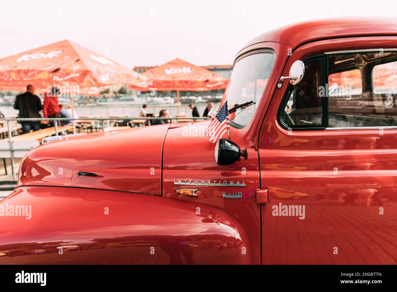 Close Side View Of Red International Harvester R-series Truck With Small American Flag Parked In Street. Stock Photo