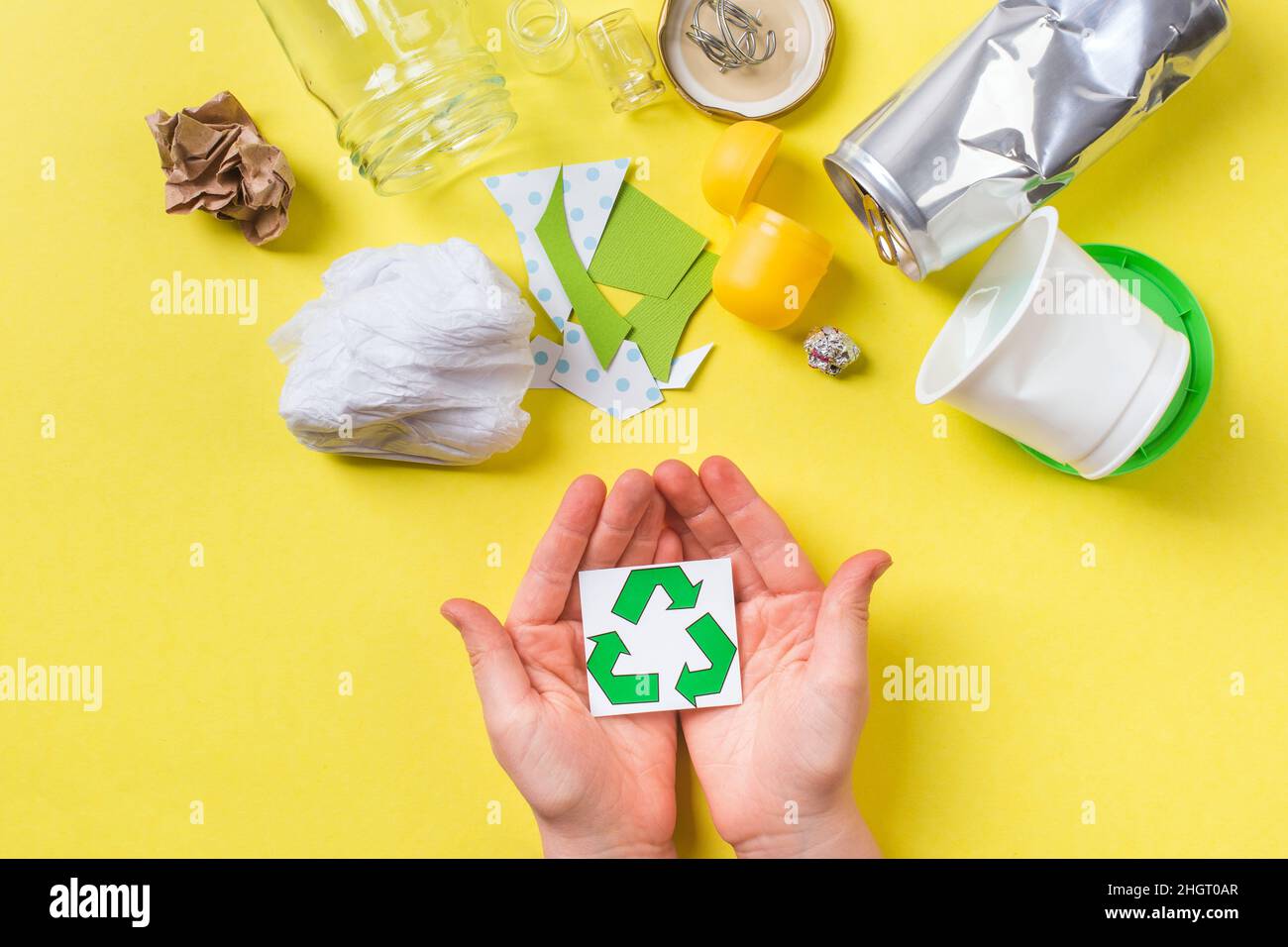 Recycle sign in child hands, clean trash metal, plastic paper and glass