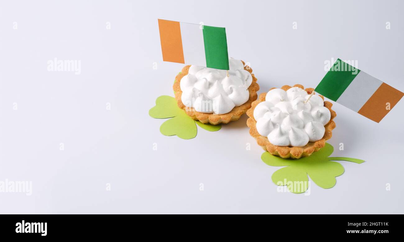 Tarts with cream and flags of Ireland on a white background. St. Patrick's Day, March 17, copying space Stock Photo