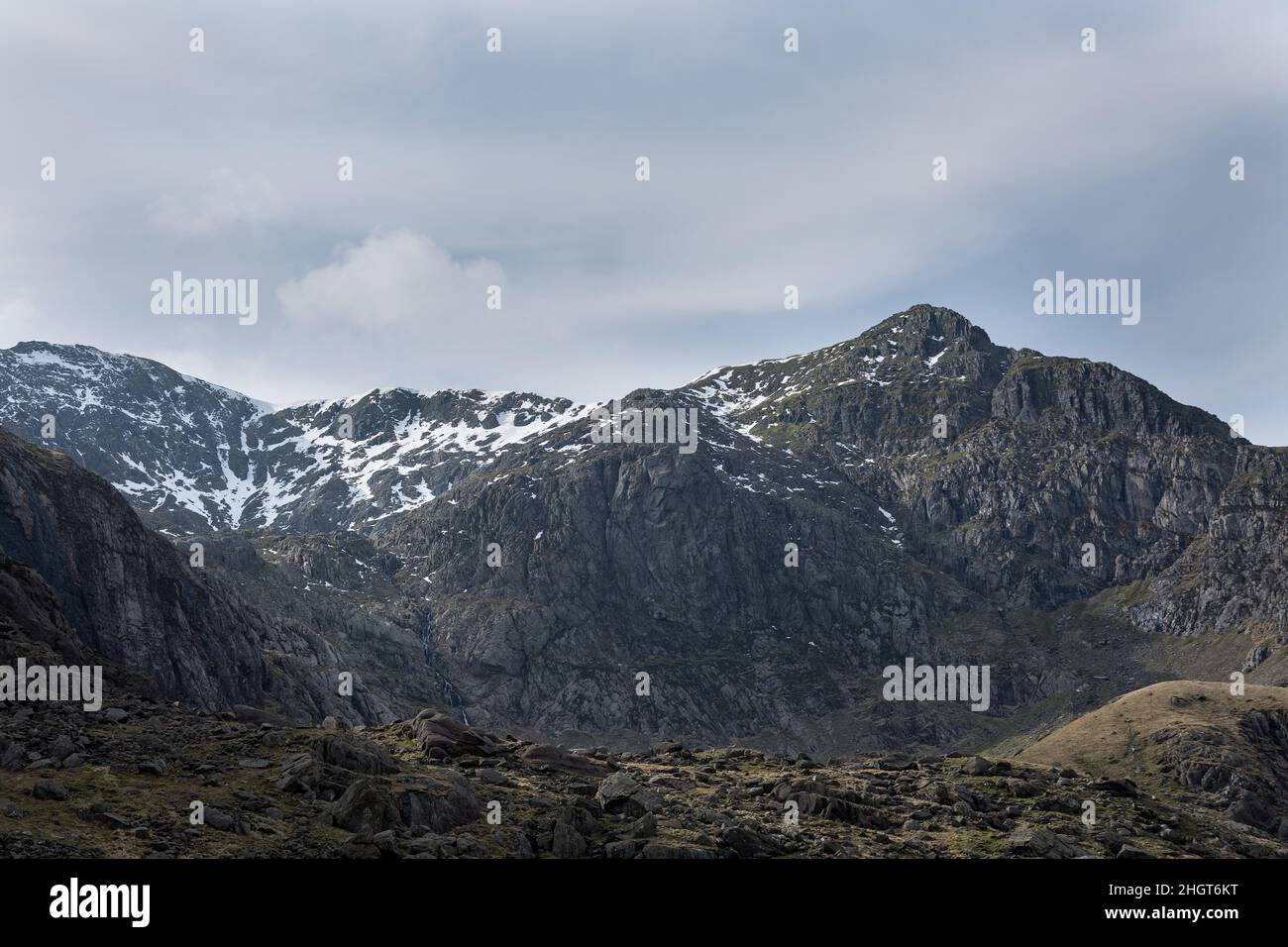 dark rock mountain range in Snowdon with snow capped peaks north wales Stock Photo
