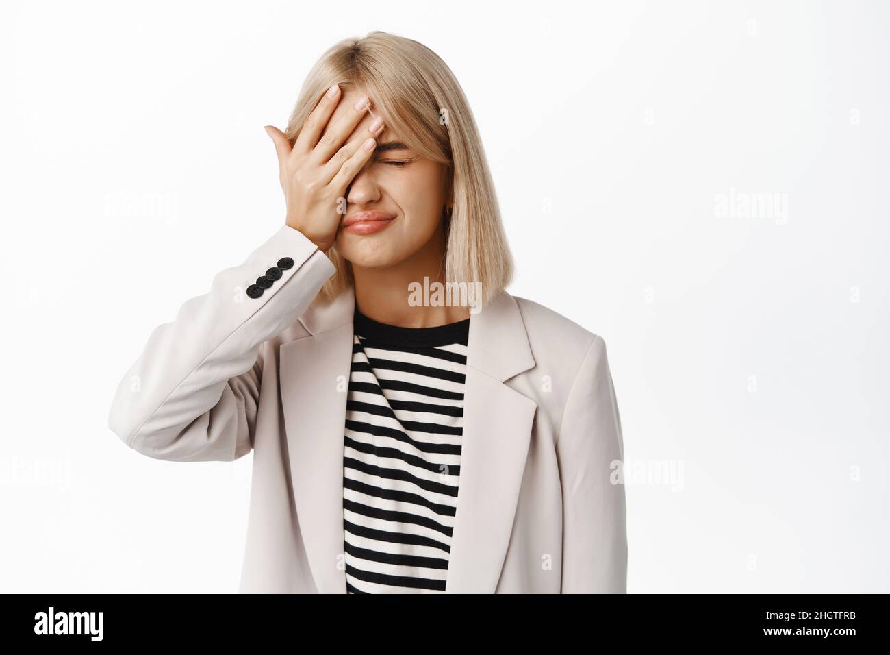 Failure. Distressed and upset businesswoman losing, making facepalm and feeling bad, standing over white background Stock Photo
