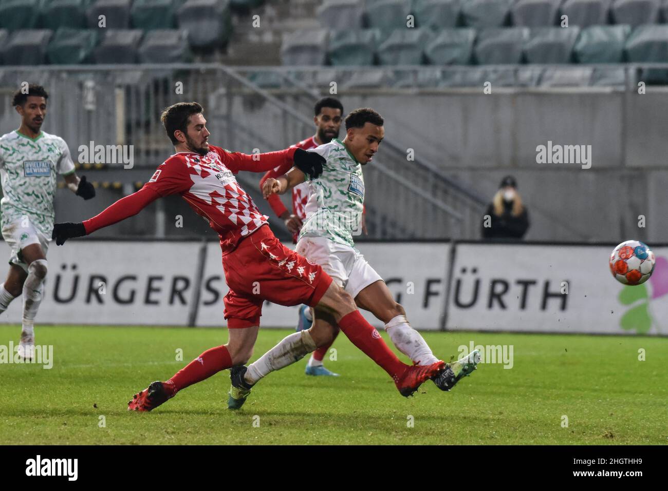 Germany ,Fuerth, Sportpark Ronhof Thomas Sommer - 22 Jan 2022 - Fussball, 1.Bundesliga - SpVgg Greuther Fuerth vs. FSV Mainz 05  Image: (fLTR) Stefan Bell (Mainz, 16) defening Jamie Leweling (SpVgg Greuther Fürth,40) as he takes a shot on goal.  DFL regulations prohibit any use of photographs as image sequences and or quasi-video Stock Photo