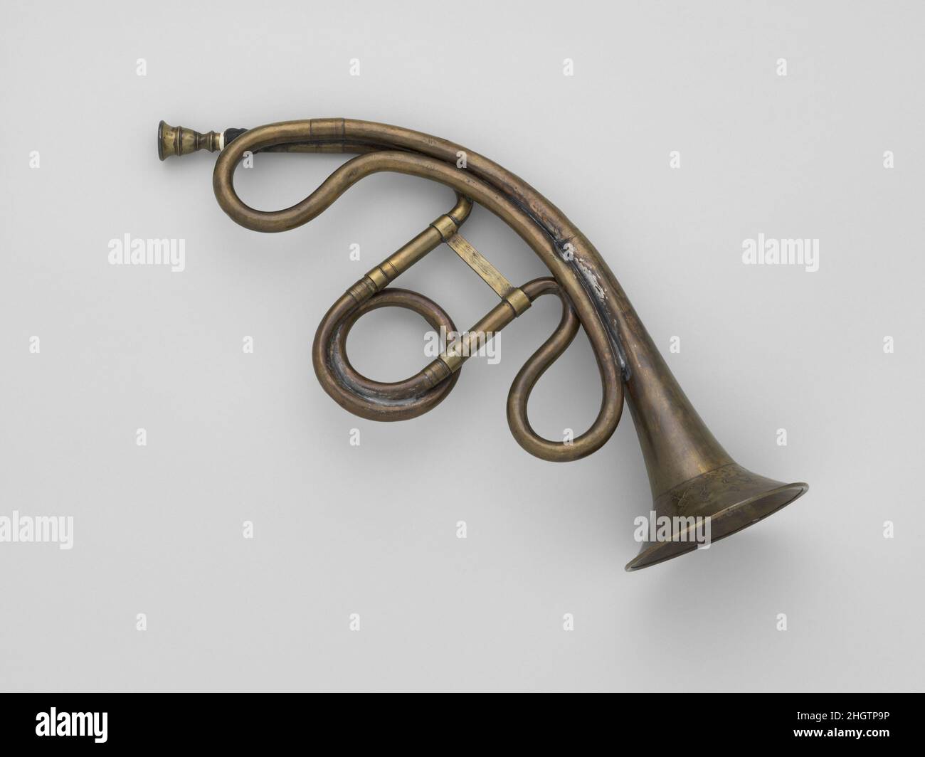 Trompette Demilune ca. 1810 German The curved form of this natural trumpet enabled the player to insert fingers into the bell and, by closing it off to varying degrees, alter the notes of the harmonic series to produce a scale. This stopping technique is similar to that used by hand horn players, but the smaller size of the trumpet’s bell made it less effective.. Trompette Demilune. German. ca. 1810. Brass. Markneukirchen, Germany. Aerophone-Lip Vibrated Stock Photo