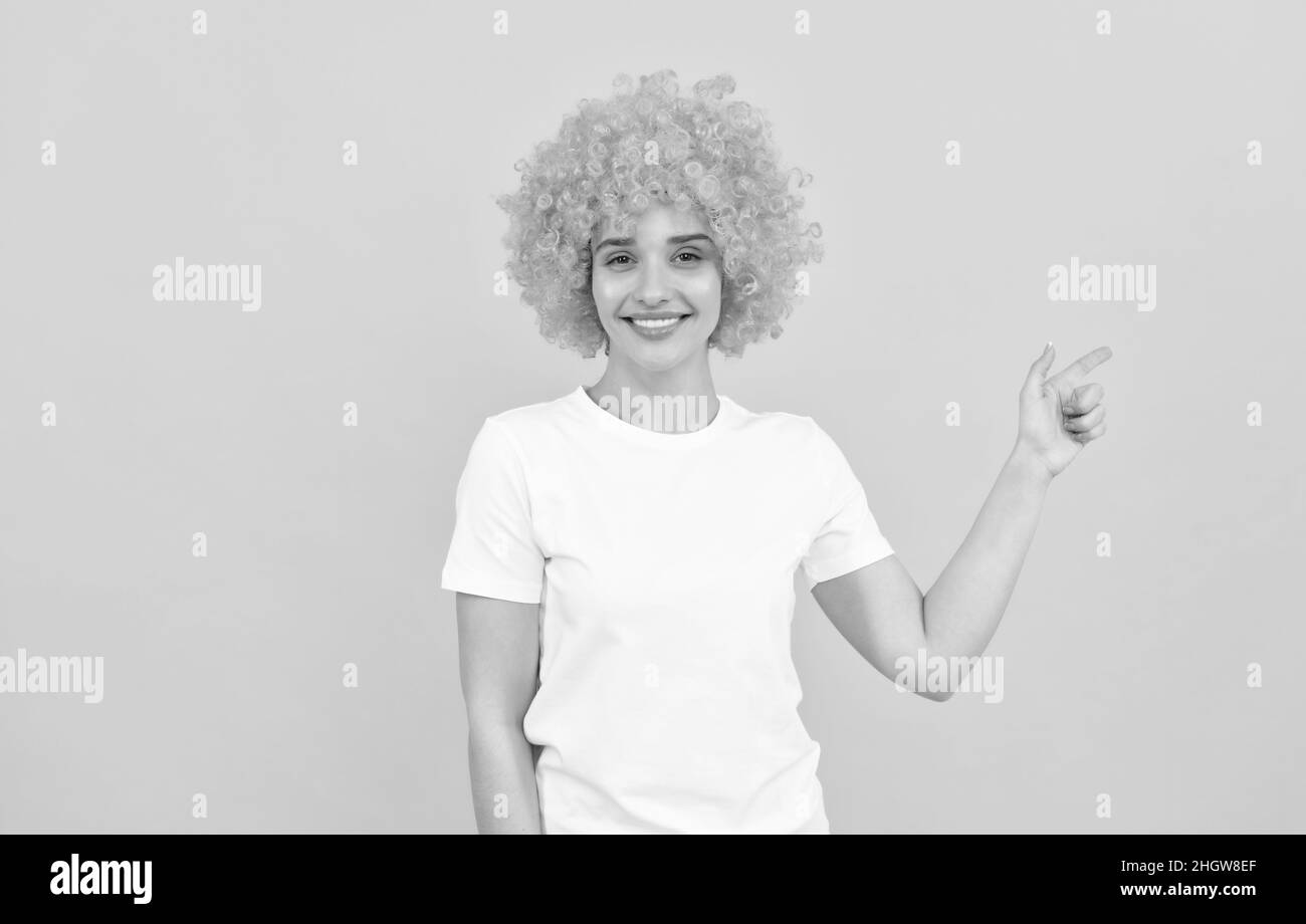 happy freaky woman in curly clown wig pointing finger, gesture and emotions Stock Photo